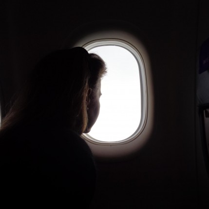 Woman. Seated on Aeroplane. Pensive.   (c) Holly Maxwell Boydell   www.TheHollyTreeTales.com